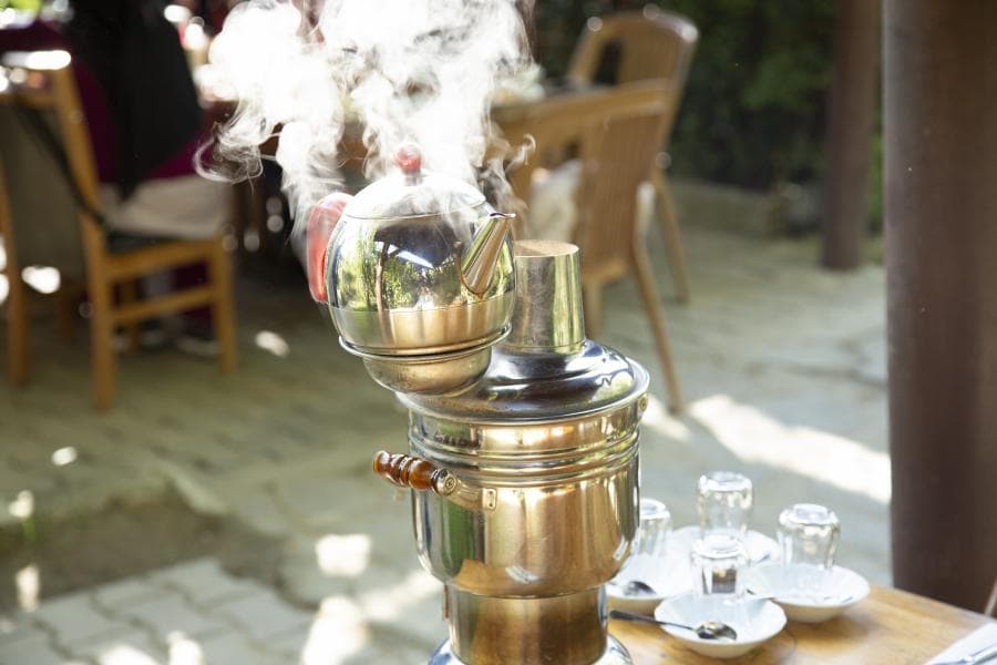 Bahçede buharı tüten semaver ve çay bardakları