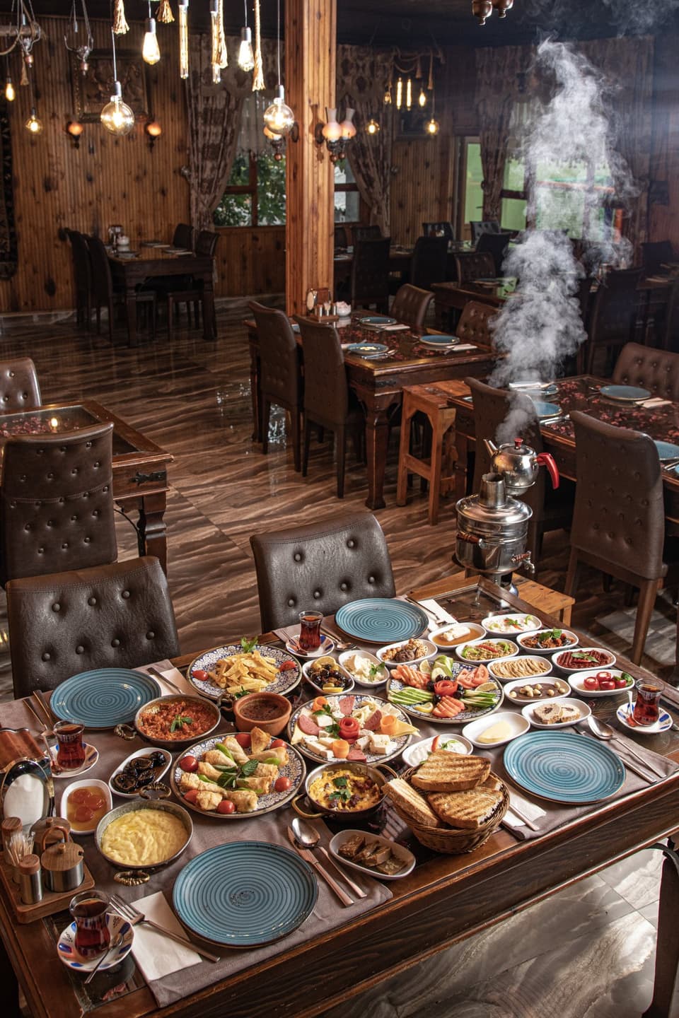 Dumanı tüten semaver ve serpme kahvaltı tabakları